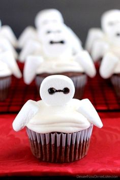 some cupcakes with white frosting and ghost faces on them