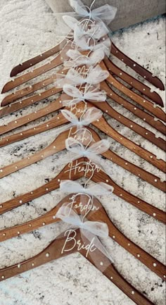 wooden clothes hangers with personalized names on them and bows tied to the top