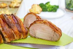 sliced meat sitting on top of a green cutting board