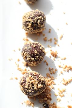 three chocolate truffles on a white surface with crumbs all over them