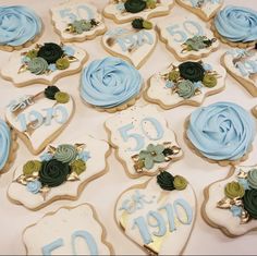 decorated cookies with blue icing and green leaves on them are arranged in the shape of flowers