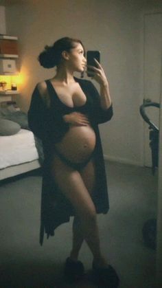 a pregnant woman taking a selfie with her cell phone