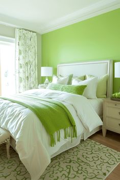 a bedroom with green walls and white bedding