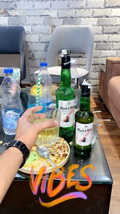 a person is eating at a table with bottled water and sodas on the table