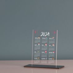 a clear desk calendar on top of a wooden stand