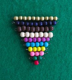 a triangle made out of candy beads on a green surface