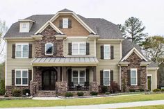 a two story house with stone and brick accents