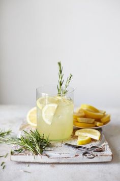 a glass filled with lemonade and garnish next to sliced lemons on a cutting board