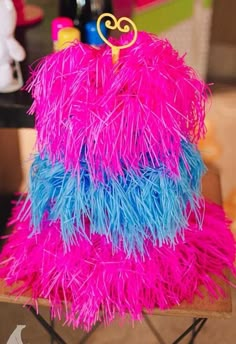 a pink and blue cake sitting on top of a wooden table