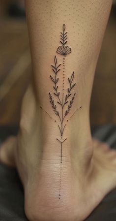 a woman's foot with a flower tattoo on the side of her leg,