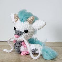 a crocheted stuffed animal with horns on it's head sitting on a table