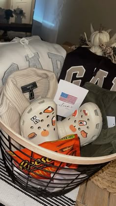 a basket filled with hockey gear on top of a table next to a pile of pillows