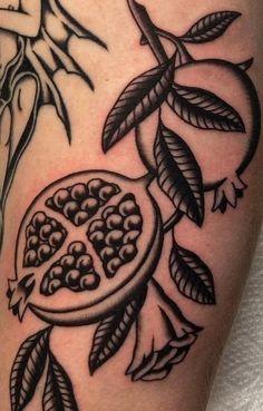 a black and white photo of a pomegranate tattoo