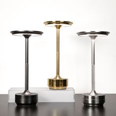 three different types of lamps sitting on top of a table next to eachother