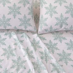 a bed with white and green snowflakes on it