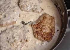 a close up of food in a pan on a stove with the words cube steak and milk gravy