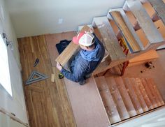 a man is working on wood floors in a house that has been built into the floor