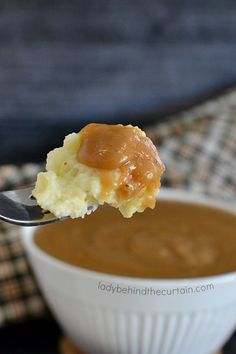 a spoon full of mashed potatoes and caramel sauce