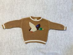 Mallard Duck hand embroidered on soft knit baby sweater.  Personalization options available.  If the color/size you want is not listed, message me and I can try and make what you want. The sweaters run large. *Actual item may vary from photo slightly due to hand embroidery. Embroidered Knit Long Sleeve Sweater, Embroidered Long Sleeve Cozy Sweater, Embroidered Long Sleeve Knit Sweater, Cute Long Sleeve Embroidered Sweater, Cozy Long Sleeve Embroidered Sweater, Embroidered Crew Neck Knit Sweater, Handmade Brown Sweater With Long Sleeves, Handmade Long Sleeve Top For Fall, Cute Custom Embroidered Sweater For Winter