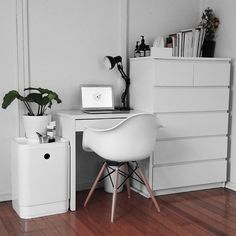 a white desk with a laptop on top of it next to a potted plant