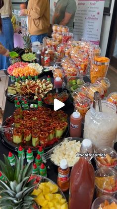 a buffet table filled with lots of food and drinks on it's sides, including pineapples