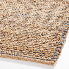 an area rug with blue and beige stripes on the bottom, in front of a white wall