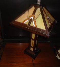 a stained glass lamp sitting on top of a wooden table