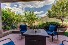 an outdoor patio with blue chairs and a table