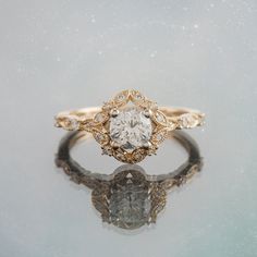 a close up of a diamond ring on a reflective surface