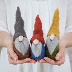 three small gnomes are held in their hands