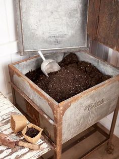 an old metal box filled with dirt sitting on top of a table