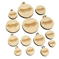 twelve pairs of fake eyelashes on wooden discs, each with a single pair of false lashes