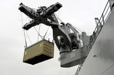 a cargo ship being lifted by a crane