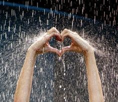 two hands making a heart shape in the rain