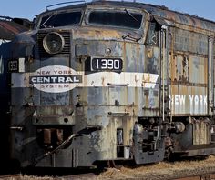 an old rusty train sitting on the tracks