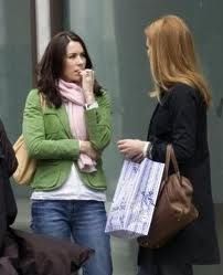 three women are standing outside talking on their cell phones