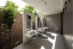 a bathroom with three sinks and two mirrors on the wall next to each other in front of a brick wall