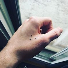 a person's left hand with tiny black dots on the middle of their thumb