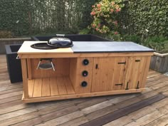 an outdoor bbq grill on a wooden deck