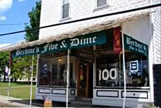 the front of a building with many signs on it's windows and awnings