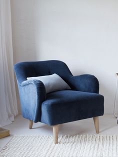 a blue chair sitting on top of a white rug