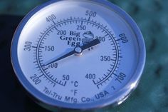 an analog thermometer with green eggs on it