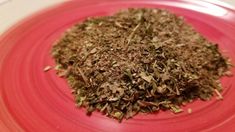 a pile of dried herbs sitting on top of a red plate