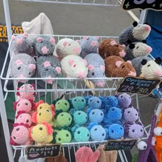 there are many crocheted stuffed animals in the basket on this cart, and one is for sale