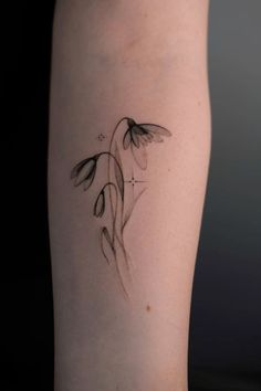 a woman's leg with a tattoo on it that has flowers growing out of it