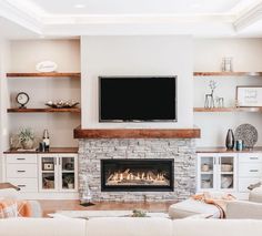 a living room filled with furniture and a flat screen tv mounted above a fire place