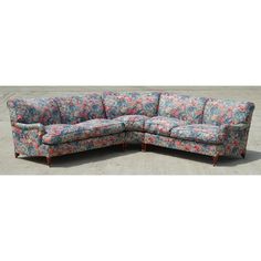 a blue and red floral print sectional sofa with matching footrests on concrete flooring