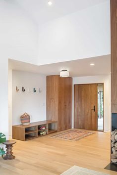 a living room with wood floors and white walls, including a fire place in the center