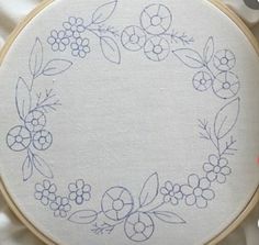 an embroidered wreath with berries and leaves on it