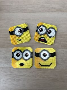 four square coasters made out of perforated material with minion faces on them